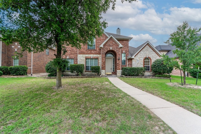 14779 Blakehill Dr, Frisco, TX 75035 - traditional-style house featuring a chimney, a front lawn, stone siding, and brick siding