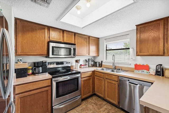 4900 Highbank Dr, Arlington, TX 76018 - kitchen with appliances with stainless steel finishes, a textured ceiling, light countertops, and brown cabinets