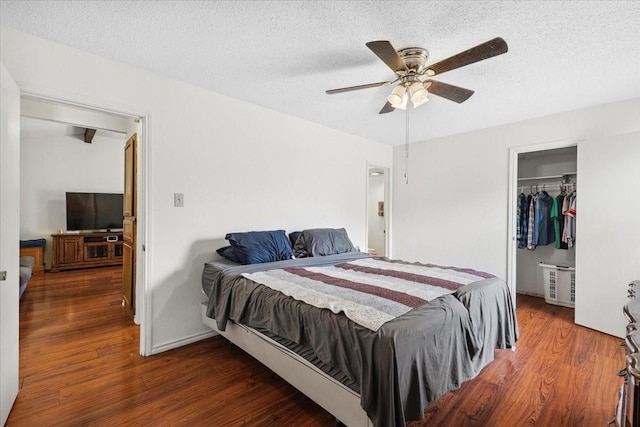 4900 Highbank Dr, Arlington, TX 76018 - bedroom featuring wood finished floors, a textured ceiling, a spacious closet, a closet, and a ceiling fan