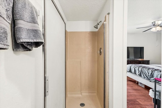 4900 Highbank Dr, Arlington, TX 76018 - ensuite bathroom with a stall shower, a textured ceiling, a ceiling fan, and wood finished floors