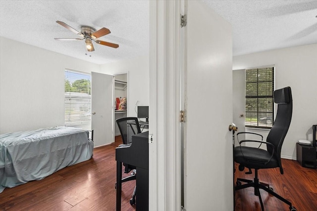4900 Highbank Dr, Arlington, TX 76018 - bedroom with a textured ceiling, a desk, wood finished floors, a walk in closet, and a ceiling fan