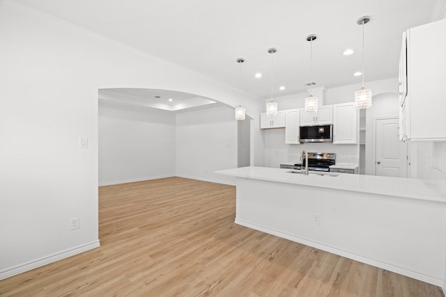 301 Henry St, Waxahachie, TX 75165 - kitchen featuring appliances with stainless steel finishes, arched walkways, white cabinetry, crown molding, and recessed lighting