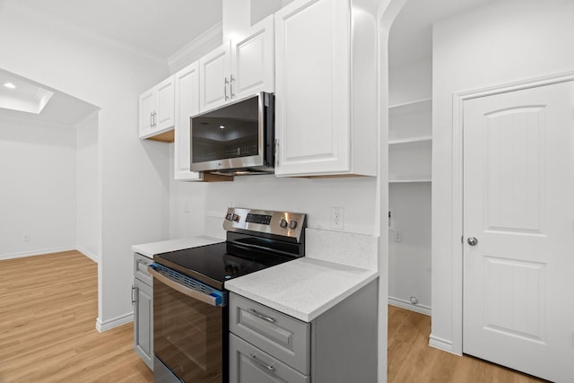 301 Henry St, Waxahachie, TX 75165 - kitchen with stainless steel appliances, crown molding, light wood-style flooring, white cabinetry, and gray cabinets