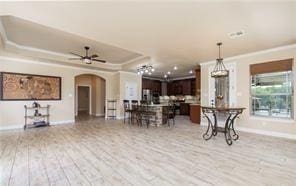 4360 Flint Oak Dr, Belton, TX 76513 - kitchen with open floor plan, arched walkways, light wood-style flooring, a raised ceiling, and dark brown cabinetry