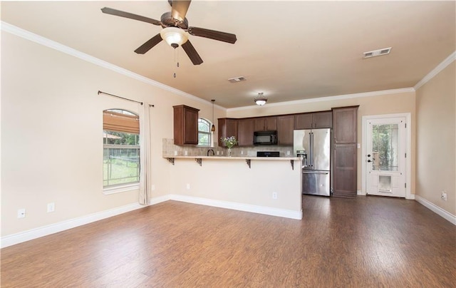 4360 Flint Oak Dr, Belton, TX 76513 - kitchen featuring high end refrigerator, black microwave, light countertops, dark wood-type flooring, and a breakfast bar