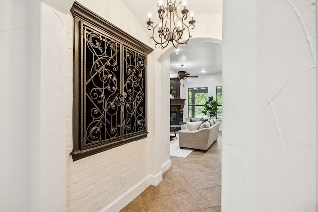 8012 Rushing Spring Dr, North Richland Hills, TX 76182 - corridor featuring light tile patterned floors, a chandelier, and arched walkways