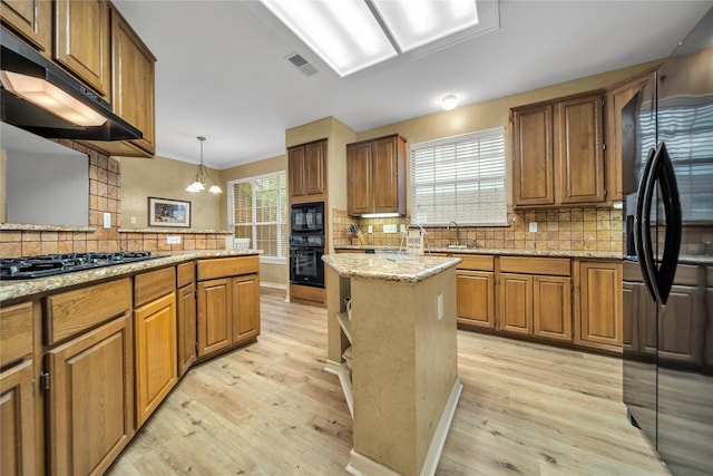 6814 Galway Dr, Garland, TX 75044 - kitchen featuring black appliances, under cabinet range hood, light wood-type flooring, tasteful backsplash, and crown molding