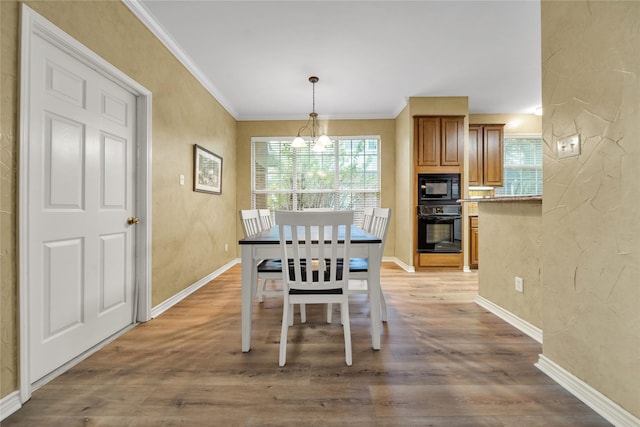6814 Galway Dr, Garland, TX 75044 - dining area with light wood finished floors, crown molding, and a chandelier