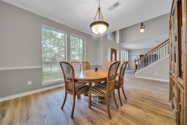 6814 Galway Dr, Garland, TX 75044 - dining area with stairs, light wood finished floors, and crown molding