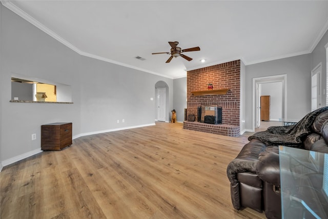 6814 Galway Dr, Garland, TX 75044 - living room featuring a ceiling fan, crown molding, arched walkways, light wood-style flooring, and a brick fireplace