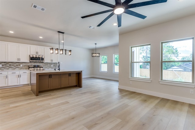 5223 Fletcher Ave, Fort Worth, TX 76107 - kitchen featuring appliances with stainless steel finishes, ceiling fan, white cabinetry, light countertops, and decorative backsplash