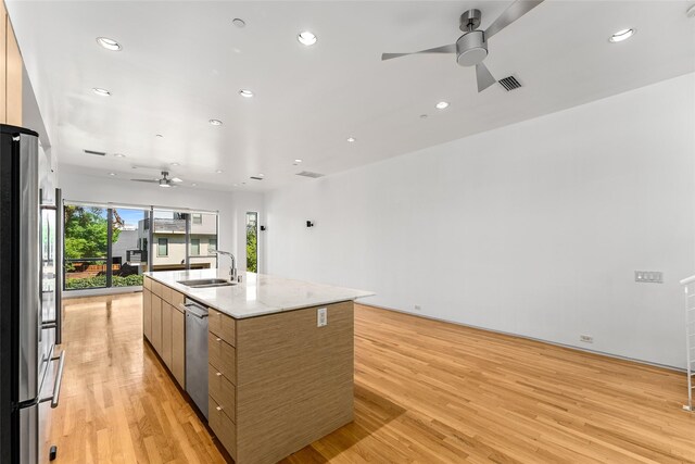 1505 N Haskell Ave Unit 5, Dallas, TX 75204 - kitchen featuring a ceiling fan, modern cabinets, appliances with stainless steel finishes, a kitchen island with sink, and light wood finished floors