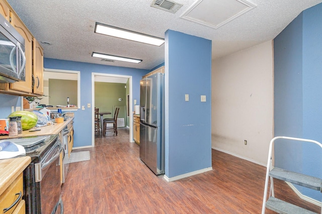 1740 Alameda Dr, Mesquite, TX 75150 - kitchen with stainless steel appliances, light countertops, dark wood-type flooring, and a textured ceiling