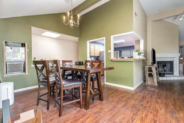 1740 Alameda Dr, Mesquite, TX 75150 - dining space featuring wood finished floors, high vaulted ceiling, a chandelier, and a fireplace