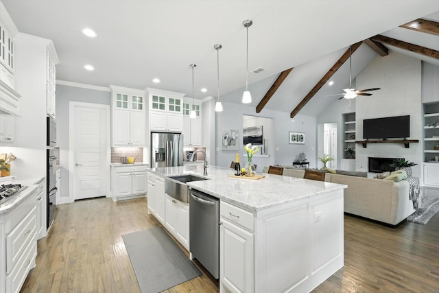 2941 American Sparrow Dr, Midlothian, TX 76065 - kitchen featuring appliances with stainless steel finishes, an island with sink, white cabinets, a ceiling fan, and tasteful backsplash