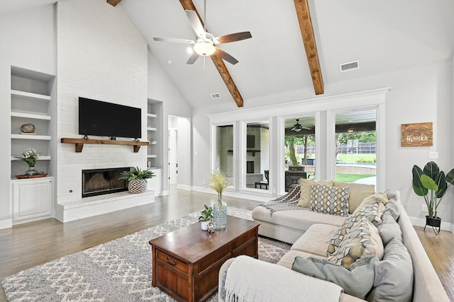 2941 American Sparrow Dr, Midlothian, TX 76065 - living area featuring a ceiling fan, wood finished floors, a fireplace, built in shelves, and high vaulted ceiling