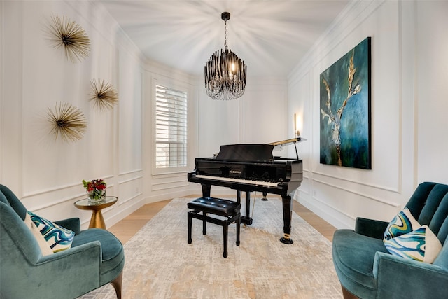 2217 Grey September St, Celina, TX 75009 - sitting room featuring a chandelier, a decorative wall, wood finished floors, and crown molding