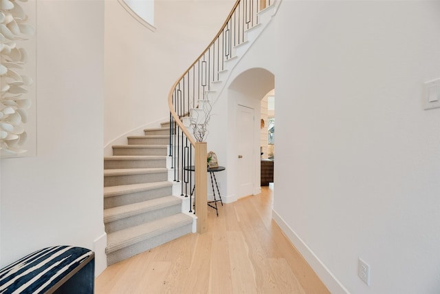 2217 Grey September St, Celina, TX 75009 - stairs featuring wood finished floors, arched walkways, and a high ceiling