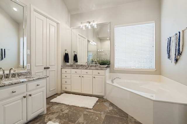 504 Rainforest Ln, Allen, TX 75013 - full bath featuring a garden tub, two vanities, and stone finish flooring