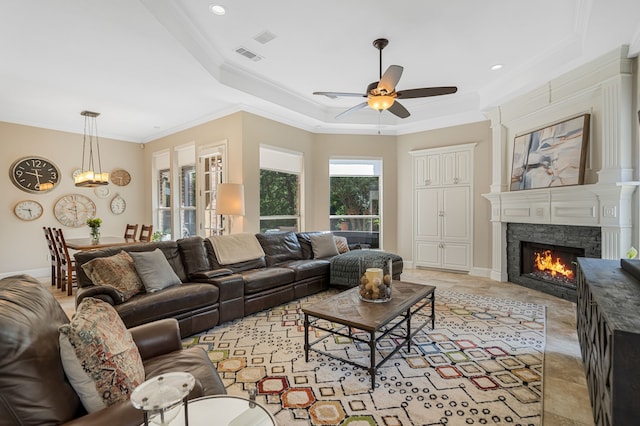 504 Rainforest Ln, Allen, TX 75013 - living room with a ceiling fan, a lit fireplace, ornamental molding, a tray ceiling, and recessed lighting