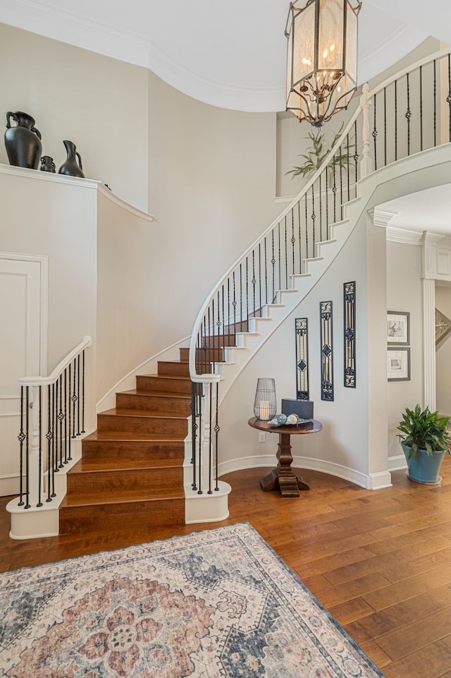 504 Rainforest Ln, Allen, TX 75013 - stairs featuring wood finished floors, ornamental molding, a chandelier, and a high ceiling