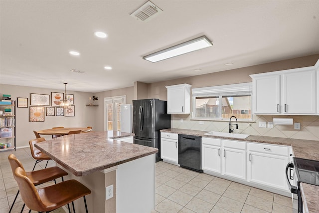 1524 Quails Nest Dr, Fort Worth, TX 76177 - kitchen featuring black appliances, decorative backsplash, a kitchen island, a kitchen bar, and white cabinets
