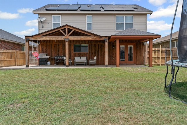 1524 Quails Nest Dr, Fort Worth, TX 76177 - rear view of house with a trampoline, a patio area, a fenced backyard, and roof mounted solar panels