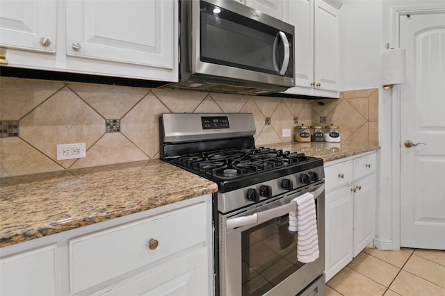 320 Grassland Dr, Denton, TX 76210 - kitchen featuring stainless steel appliances, white cabinetry, backsplash, light tile patterned floors, and light stone counters