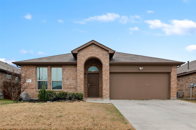 320 Grassland Dr, Denton, TX 76210 - view of front facade with a garage, concrete driveway, brick siding, and a front yard