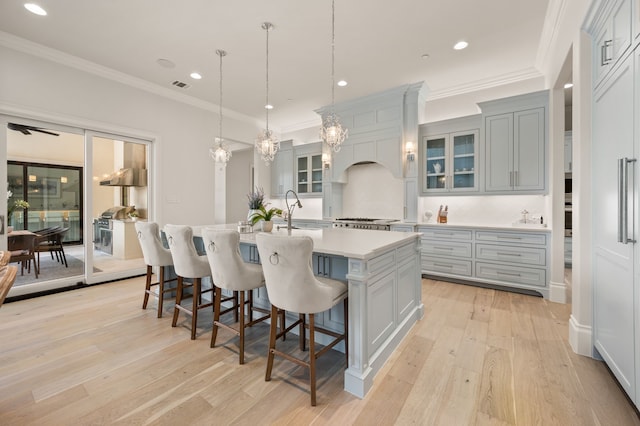 2009 Wheeler Dr, Southlake, TX 76092 - kitchen with a kitchen island with sink, light countertops, light wood-style flooring, a kitchen breakfast bar, and recessed lighting