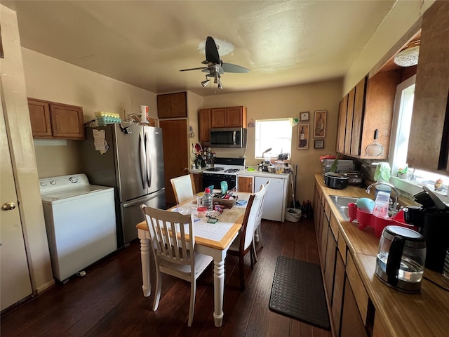 603 E Thomas St, Sherman, TX 75090 - kitchen with appliances with stainless steel finishes, washer / clothes dryer, brown cabinetry, ceiling fan, and dark wood finished floors