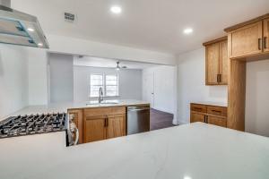136 Edgefield Dr, Garland, TX 75040 - kitchen featuring dishwasher, light countertops, ventilation hood, recessed lighting, and brown cabinets