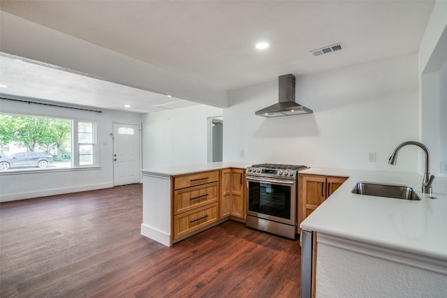 136 Edgefield Dr, Garland, TX 75040 - kitchen featuring stainless steel range with gas stovetop, wall chimney exhaust hood, a peninsula, dark wood-style floors, and light countertops