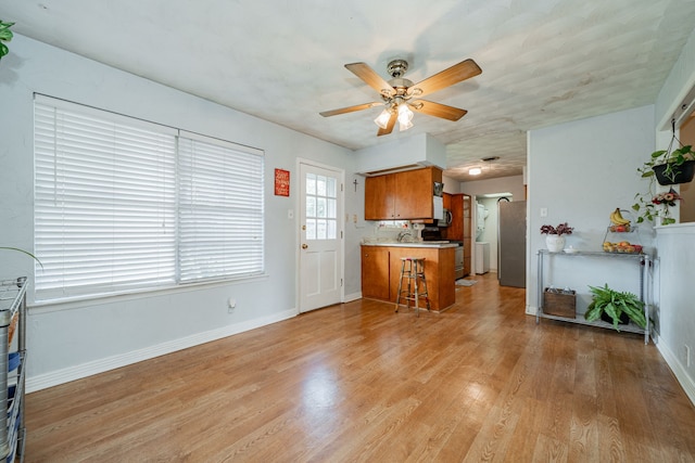 514 Fairview Dr, Richardson, TX 75081 - kitchen featuring brown cabinetry, a ceiling fan, light wood-style floors, a peninsula, and light countertops