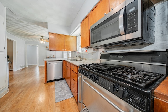 514 Fairview Dr, Richardson, TX 75081 - kitchen with stainless steel appliances, light wood-type flooring, brown cabinetry, light countertops, and a ceiling fan