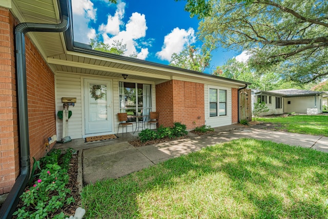 514 Fairview Dr, Richardson, TX 75081 - property entrance featuring a lawn, covered porch, and brick siding