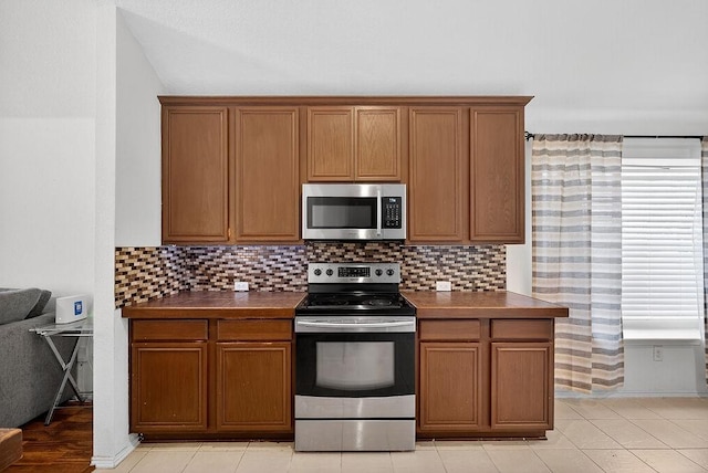 1245 Mountain Peak Dr, Fort Worth, TX 76052 - kitchen with stainless steel appliances, dark countertops, and brown cabinets