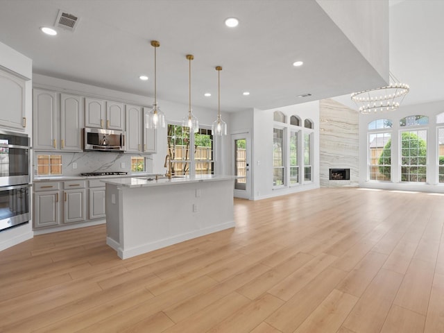 11342 Raveneaux Dr, Frisco, TX 75033 - kitchen featuring appliances with stainless steel finishes, recessed lighting, light countertops, plenty of natural light, and light wood-type flooring
