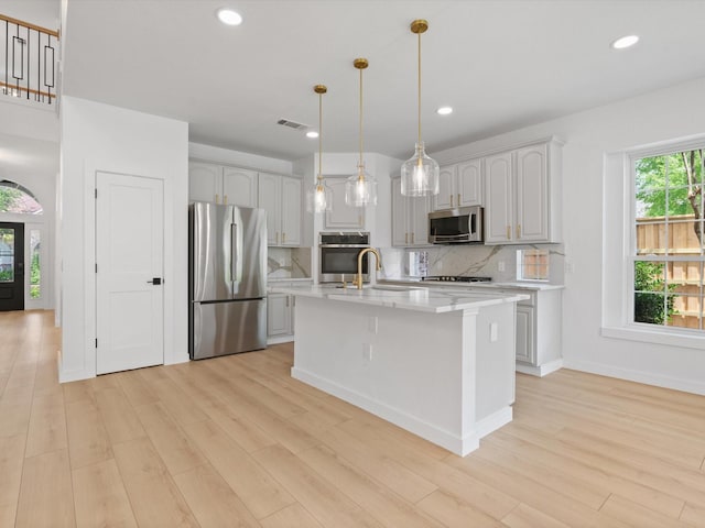 11342 Raveneaux Dr, Frisco, TX 75033 - kitchen with stainless steel appliances, light wood-style floors, backsplash, pendant lighting, and recessed lighting