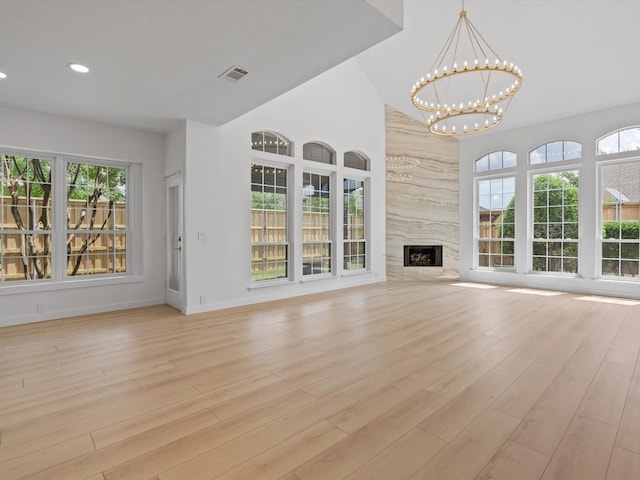 11342 Raveneaux Dr, Frisco, TX 75033 - unfurnished living room featuring a chandelier, light wood-type flooring, recessed lighting, and a fireplace