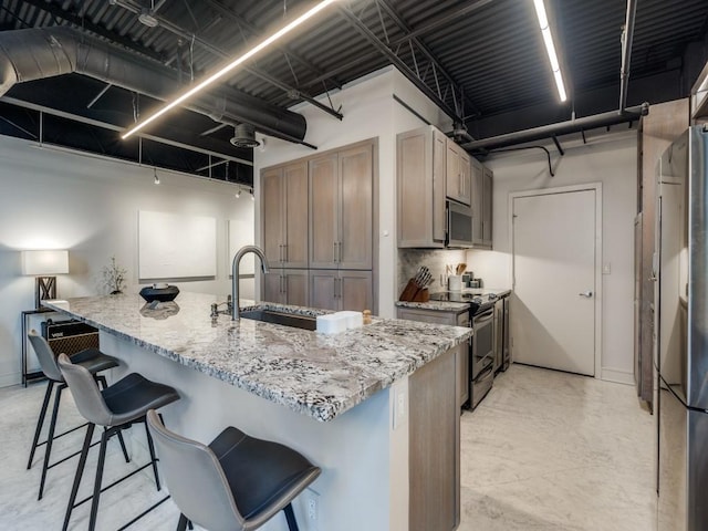 3110 Thomas Ave Unit 101, Dallas, TX 75204 - kitchen with appliances with stainless steel finishes, a kitchen bar, light stone countertops, and decorative backsplash