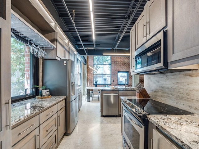3110 Thomas Ave Unit 101, Dallas, TX 75204 - kitchen with appliances with stainless steel finishes, brick wall, light stone counters, open shelves, and concrete floors