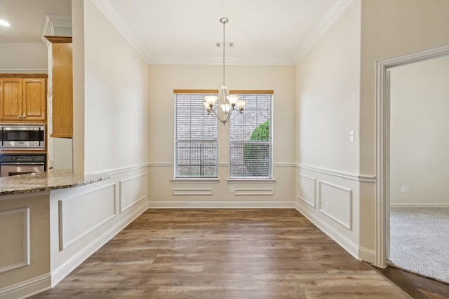 6802 Westfield Ct, Arlington, TX 76001 - unfurnished dining area with a chandelier, wood finished floors, crown molding, and wainscoting