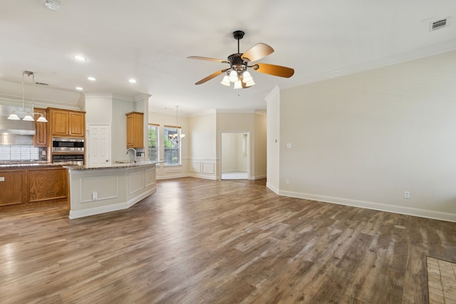 6802 Westfield Ct, Arlington, TX 76001 - kitchen featuring brown cabinetry, crown molding, stainless steel appliances, open floor plan, and a ceiling fan