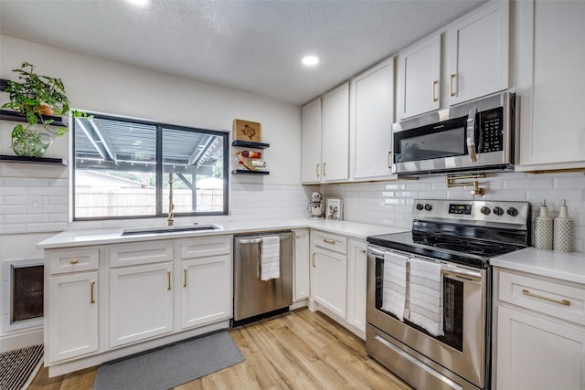 726 W Crossland Blvd, Grand Prairie, TX 75052 - kitchen featuring appliances with stainless steel finishes, open shelves, white cabinets, light wood-style flooring, and recessed lighting