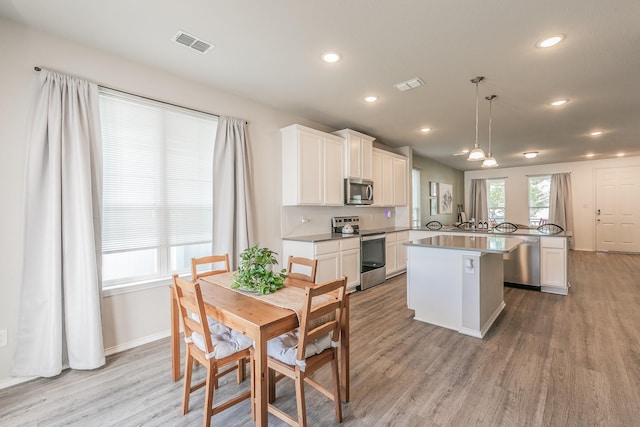 10041 Adams Ln, Providence Village, TX 76227 - kitchen with appliances with stainless steel finishes, a center island, light wood-style floors, white cabinetry, and recessed lighting
