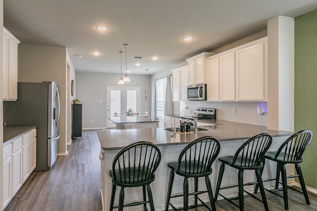 10041 Adams Ln, Providence Village, TX 76227 - kitchen with appliances with stainless steel finishes, tasteful backsplash, a peninsula, dark wood-style floors, and recessed lighting