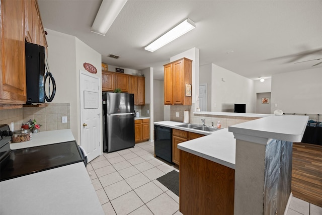 708 Hummingbird Trl, Crowley, TX 76036 - kitchen featuring black appliances, light tile patterned flooring, a peninsula, and tasteful backsplash