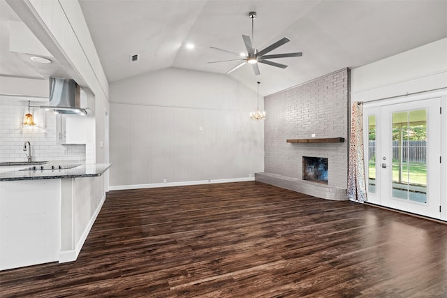 8441 Main St, North Richland Hills, TX 76182 - unfurnished living room featuring a fireplace, wood finished floors, lofted ceiling, ceiling fan, and a chandelier