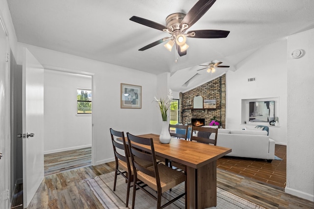 3509 Ames Rd, Lancaster, TX 75134 - dining area featuring wood finished floors, a fireplace, ceiling fan, and lofted ceiling